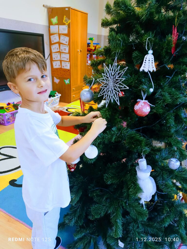 Stoi choinka, pięknie odziana. "Motylki" ją stroiły od samego rana.