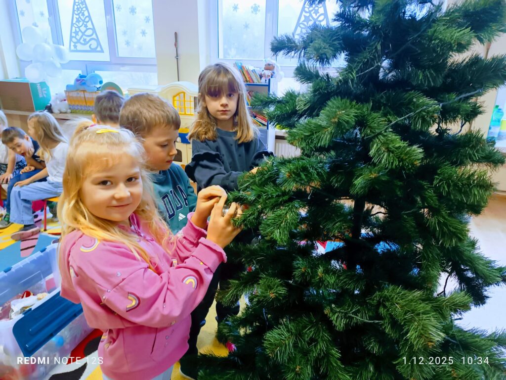 Stoi choinka, pięknie odziana. "Motylki" ją stroiły od samego rana.