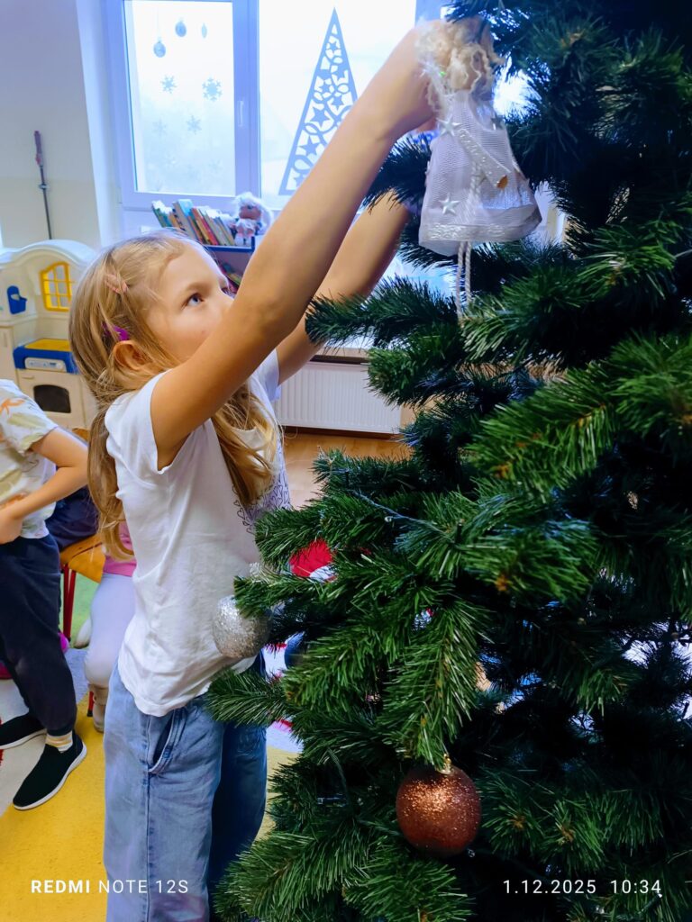 Stoi choinka, pięknie odziana. "Motylki" ją stroiły od samego rana.