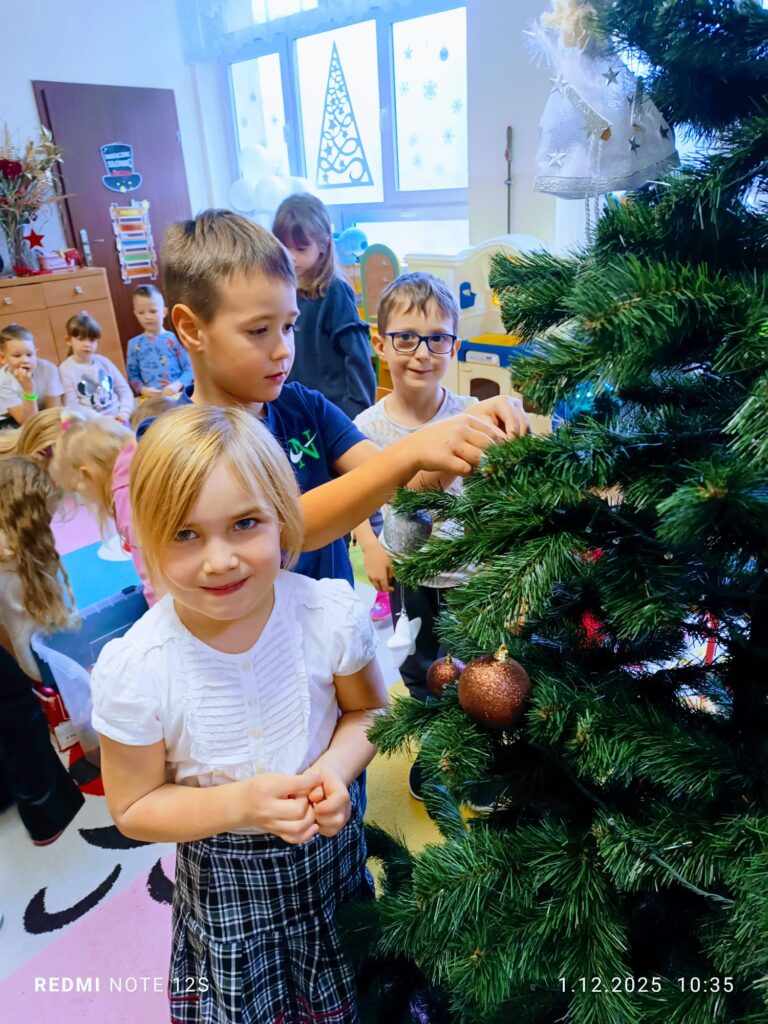 Stoi choinka, pięknie odziana. "Motylki" ją stroiły od samego rana.
