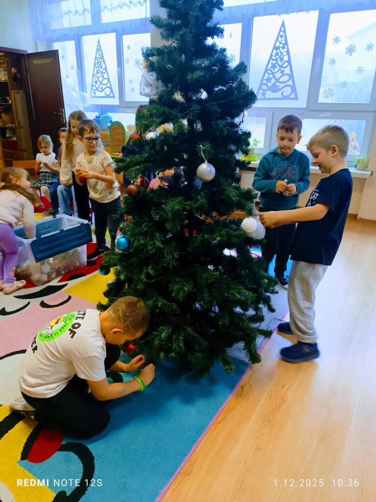 Stoi choinka, pięknie odziana. "Motylki" ją stroiły od samego rana.