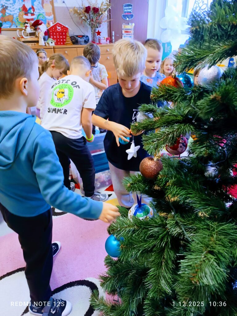 Stoi choinka, pięknie odziana. "Motylki" ją stroiły od samego rana.