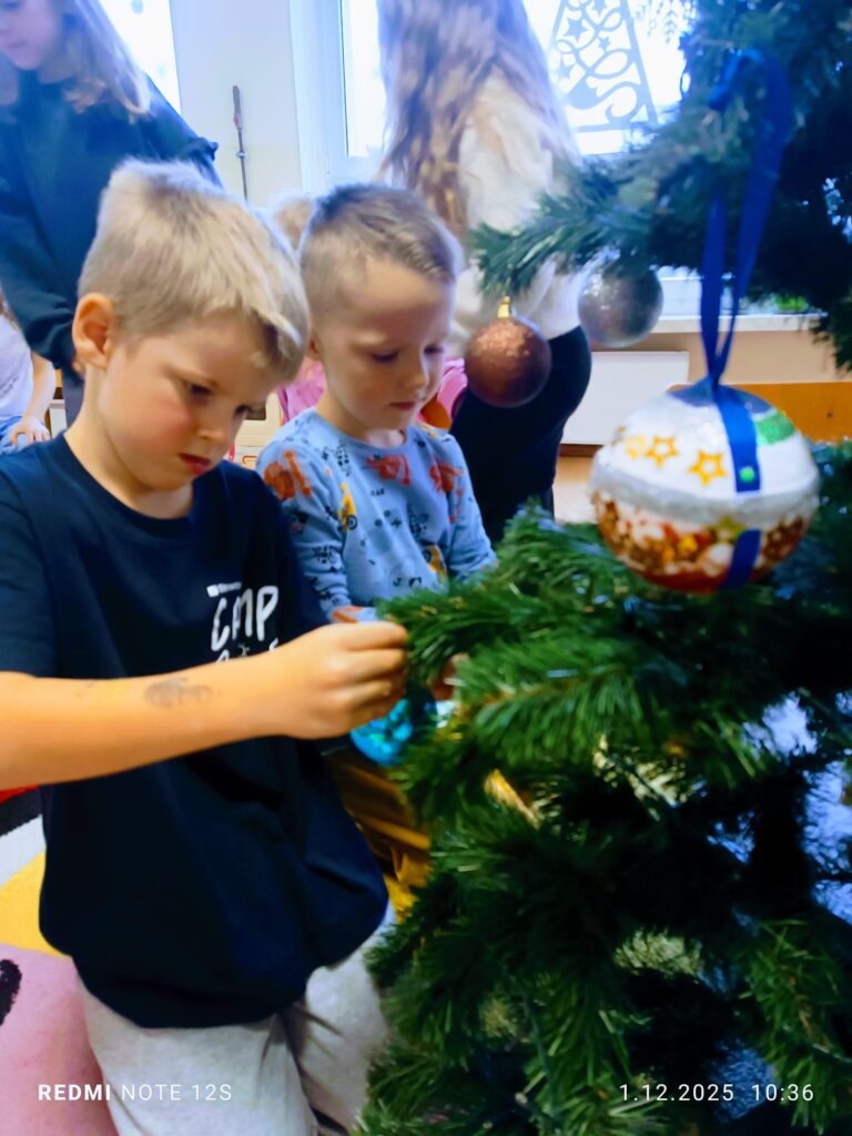 Stoi choinka, pięknie odziana. "Motylki" ją stroiły od samego rana.