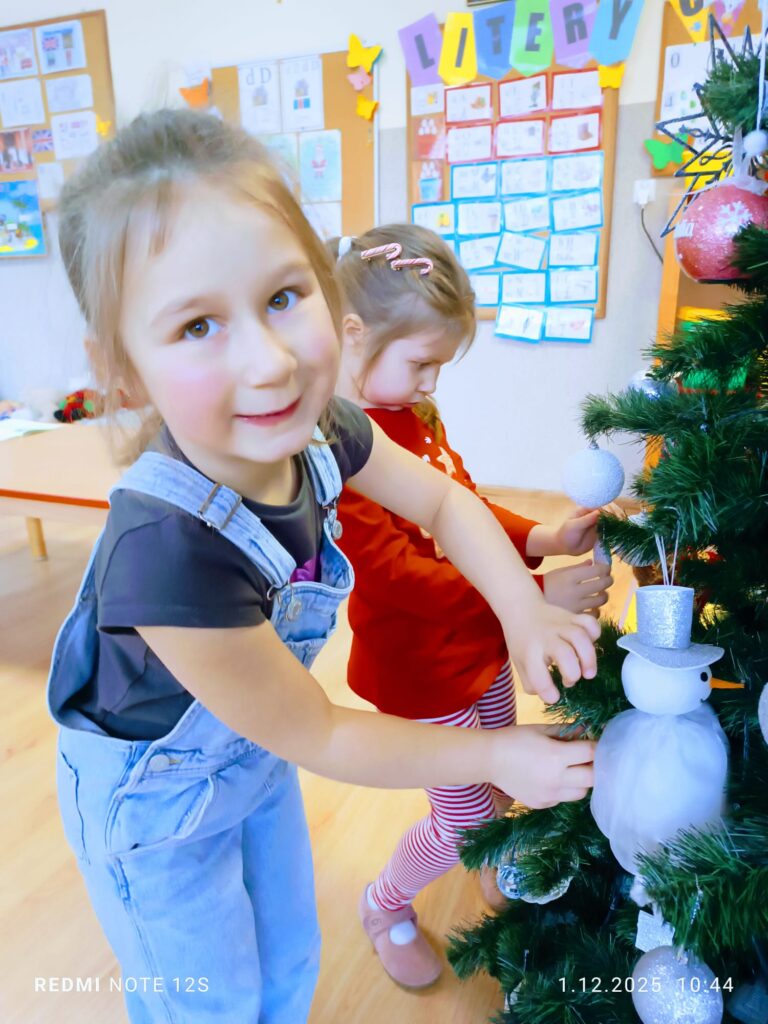 Stoi choinka, pięknie odziana. "Motylki" ją stroiły od samego rana.