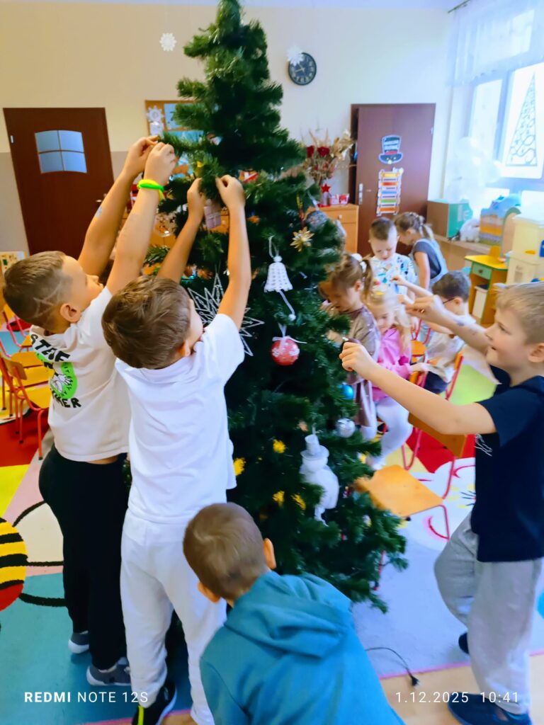 Stoi choinka, pięknie odziana. "Motylki" ją stroiły od samego rana.