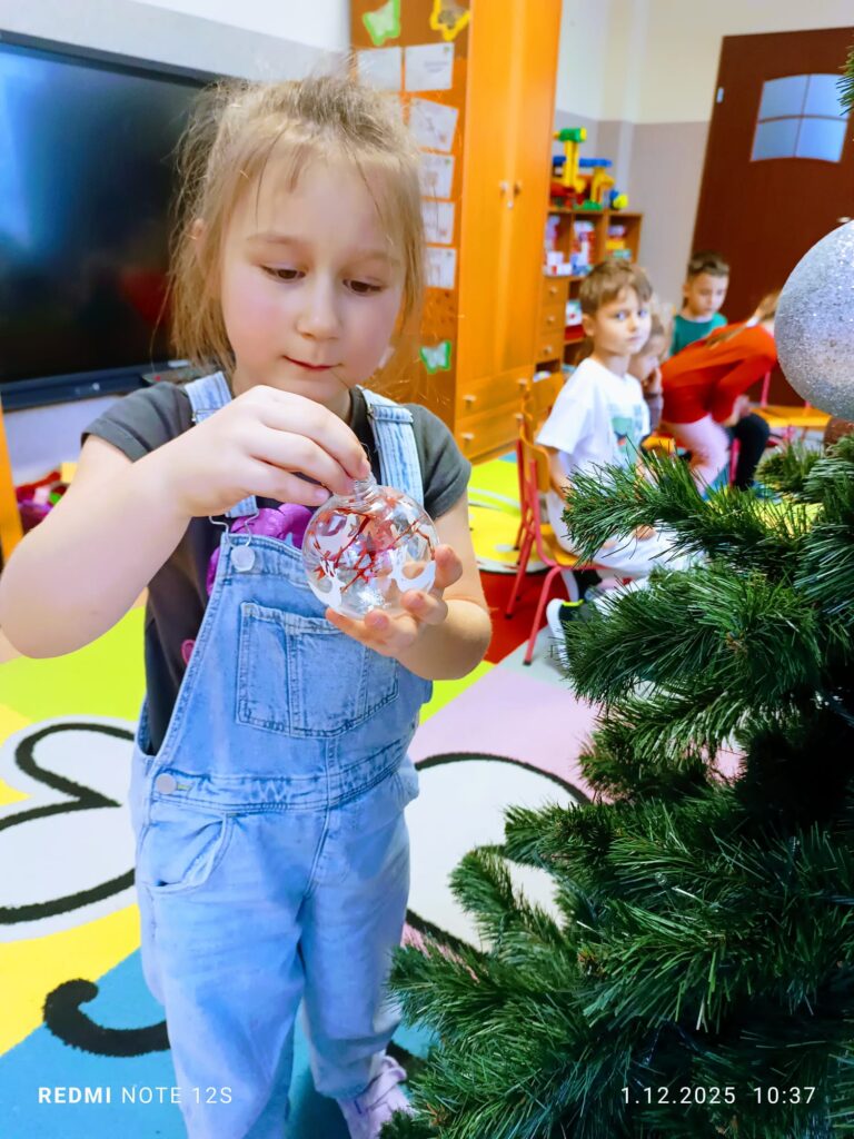 Stoi choinka, pięknie odziana. "Motylki" ją stroiły od samego rana.