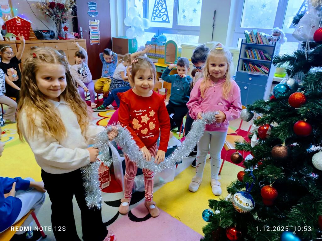 Stoi choinka, pięknie odziana. "Motylki" ją stroiły od samego rana.