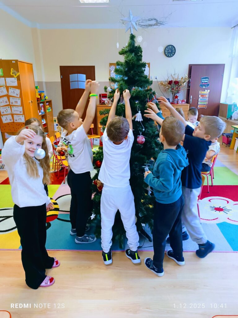 Stoi choinka, pięknie odziana. "Motylki" ją stroiły od samego rana.