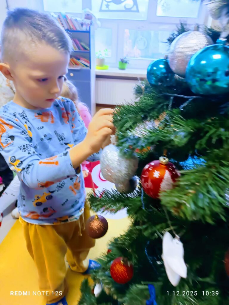 Stoi choinka, pięknie odziana. "Motylki" ją stroiły od samego rana.