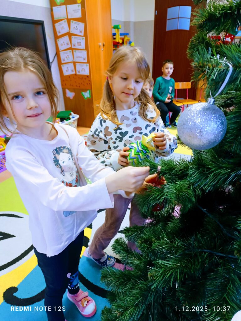 Stoi choinka, pięknie odziana. "Motylki" ją stroiły od samego rana.