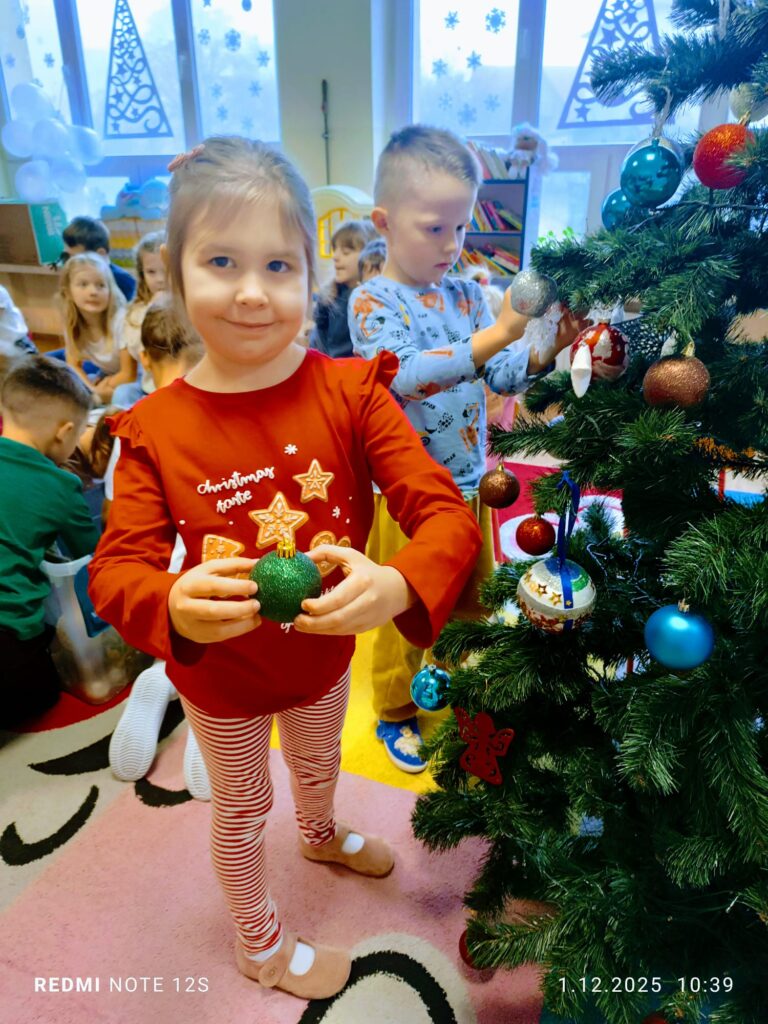 Stoi choinka, pięknie odziana. "Motylki" ją stroiły od samego rana.