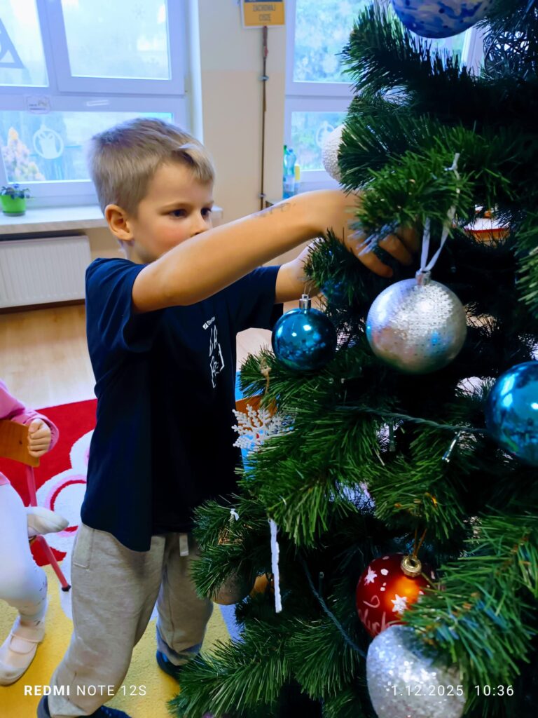 Stoi choinka, pięknie odziana. "Motylki" ją stroiły od samego rana.